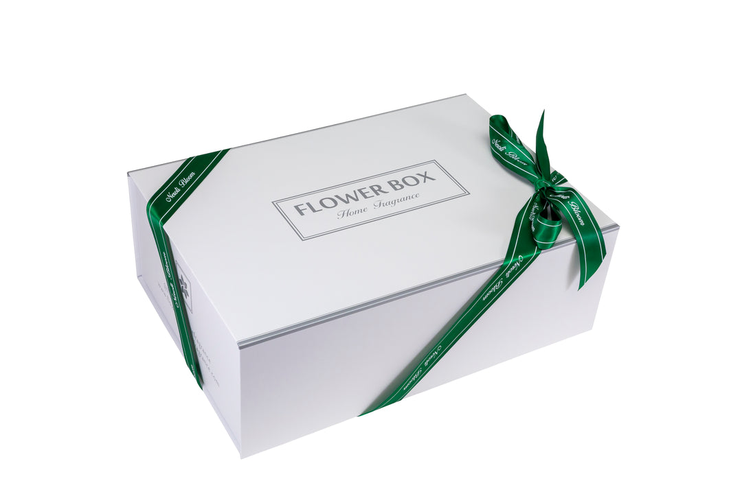 White flower box with a green ribbon on a white background